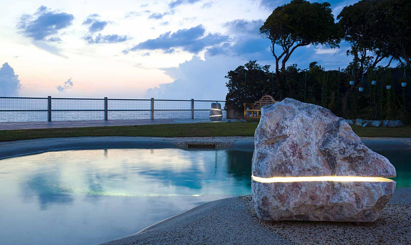 piscine lagon de nuit avec éclairage inclus dans des rochers